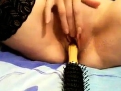 Chinese girl uses her hairbrush as a hot dildo