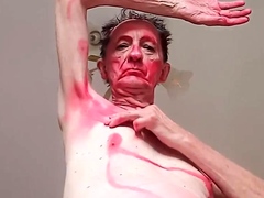 an old guy paints himself red and dances nude